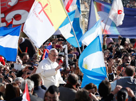 Flags from Argentina and other counties and movements are seen as Pope Francis greets the crowd before his Inaugural Mass.  CNS Photo/Paull Haring.