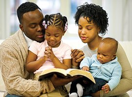 A young family reads the bible together.