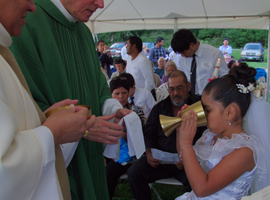 Girl receiving communion at Mass for migrants in the Diocese of Youngstown.