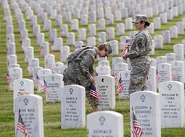 Staff Sgt. Kerrin Kampa of Mifflinburg, Pa., and Staff Sgt. Judy Dukes of Aurora, Ill., plant U.S. flags at Arlington National Cemetery in Virginia on May 23, 2013 in honor of the fallen to mark Memorial Day. CNS photo/Nancy Phelan Wiechec