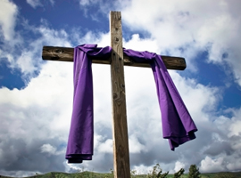 A simple wooden cross is draped in purple cross to remind us of Christ's sacrifice during the Lenten season. iStock photo