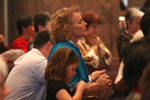 Congregation kneels in prayer. 
