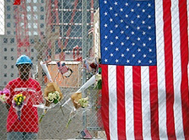 A worker looks over memorial items left on a fence near ground zero in New York. CNS Photo/Mary Knight.