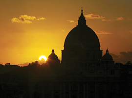 The dome of St. Peter's Basilica in Rome is illuminated at sunrise. iStock photo.