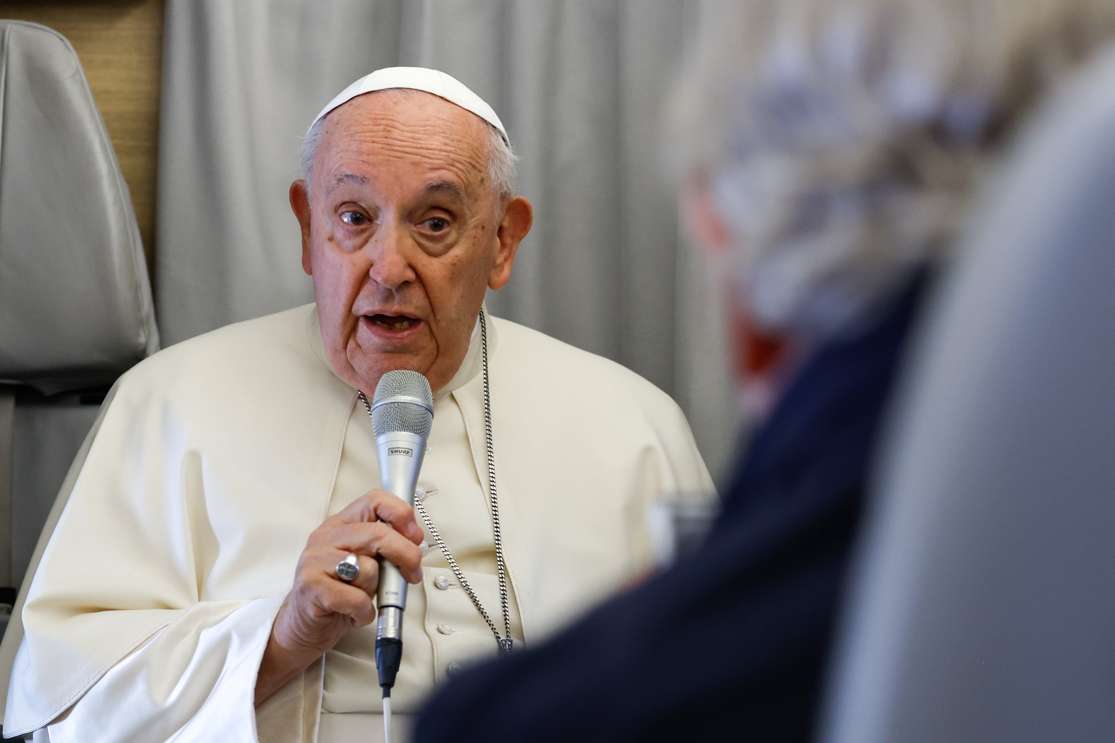 Pope Francis answers a question during an inflight press conference. 