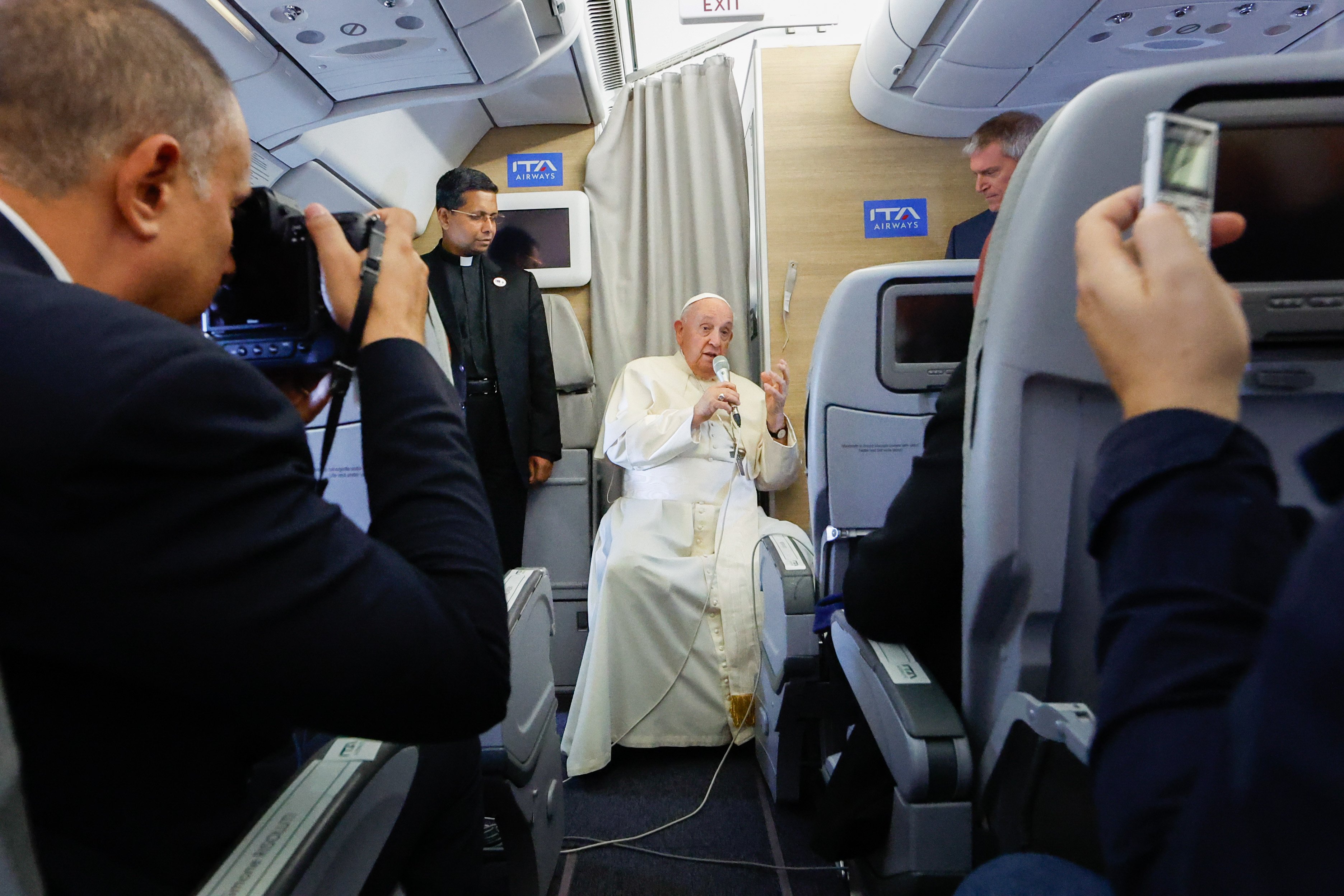 Pope Francis answers a question during an inflight press conference. 