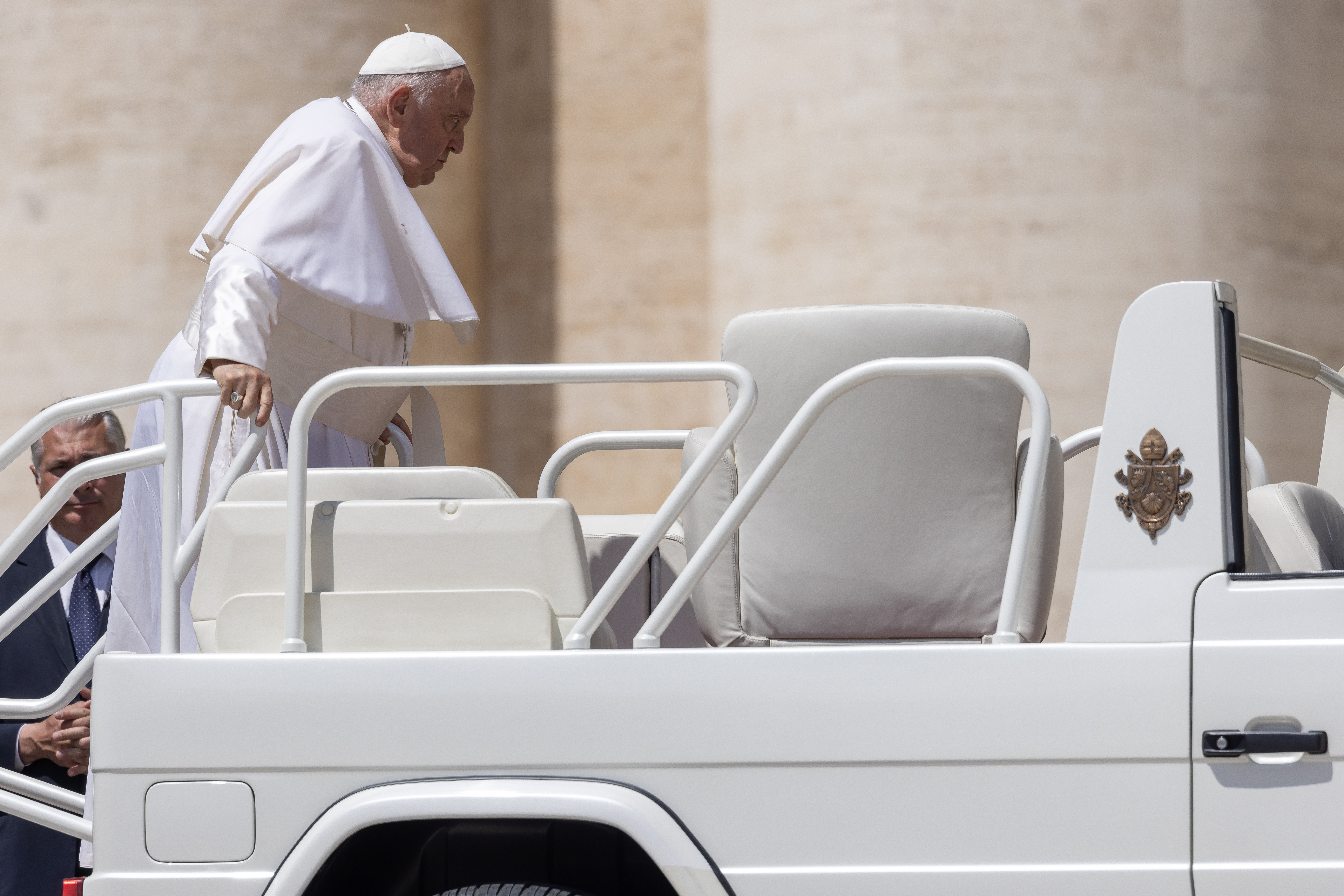 Pope Francis steps onto the popemobile.