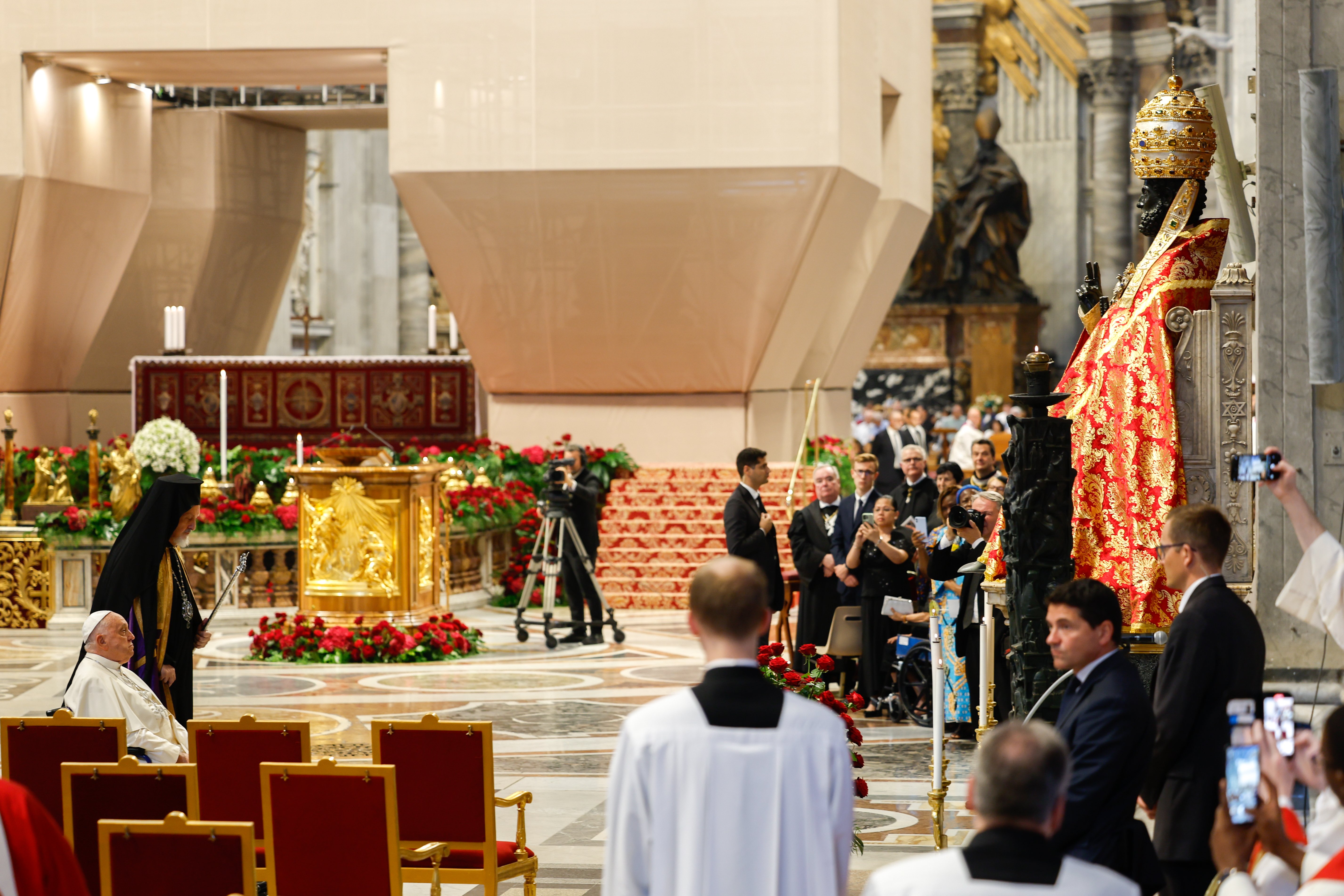 Pope Francis prays before a statue of St. Peter.