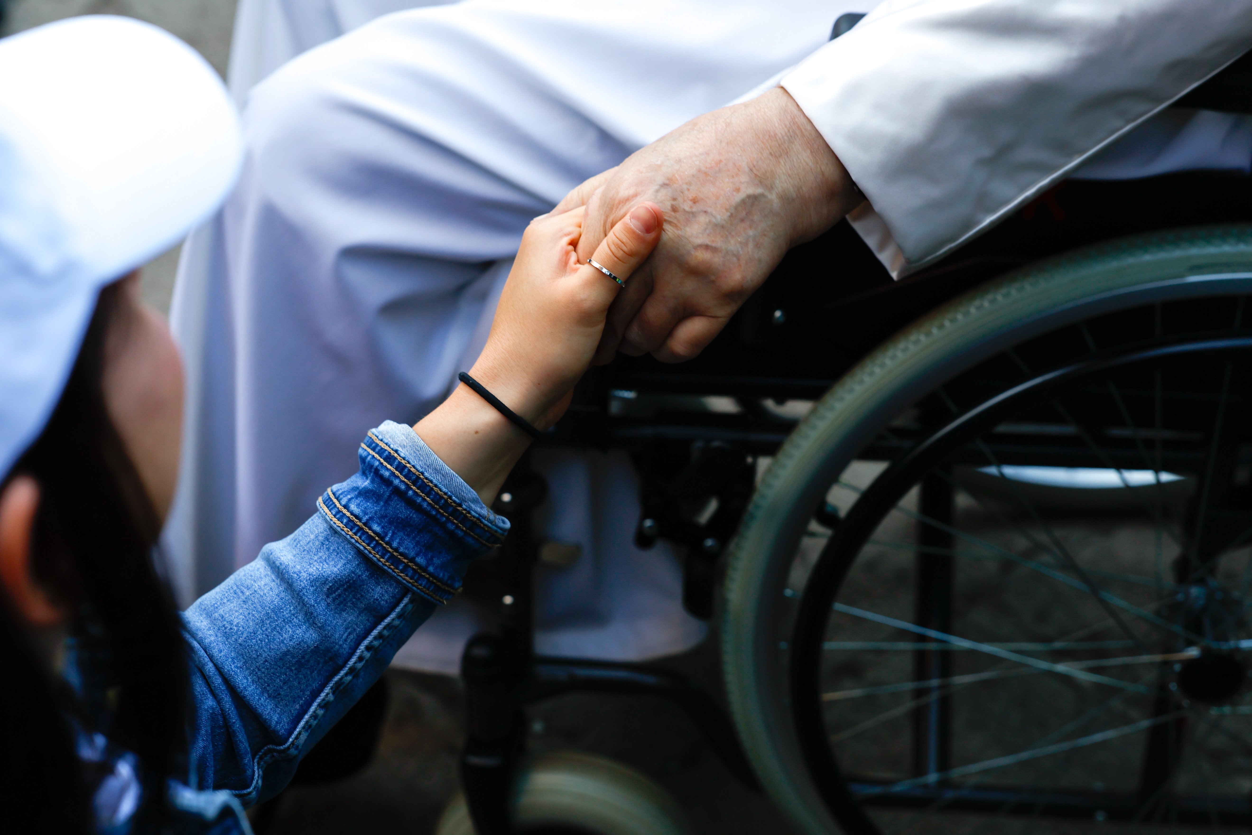 Pope Francis holds a woman's hand.