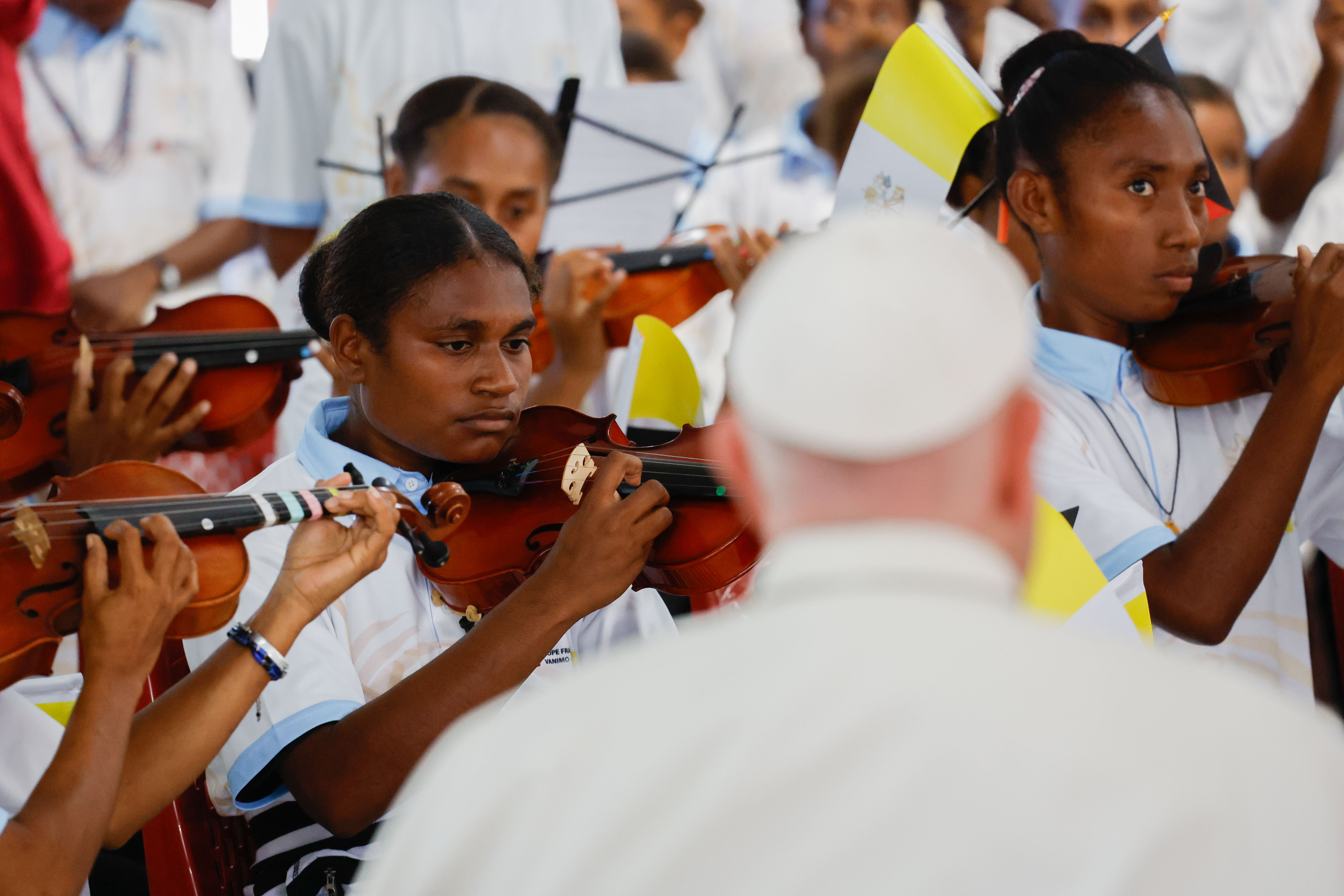 Pope Francis attends a concert performed by a student orchestra.