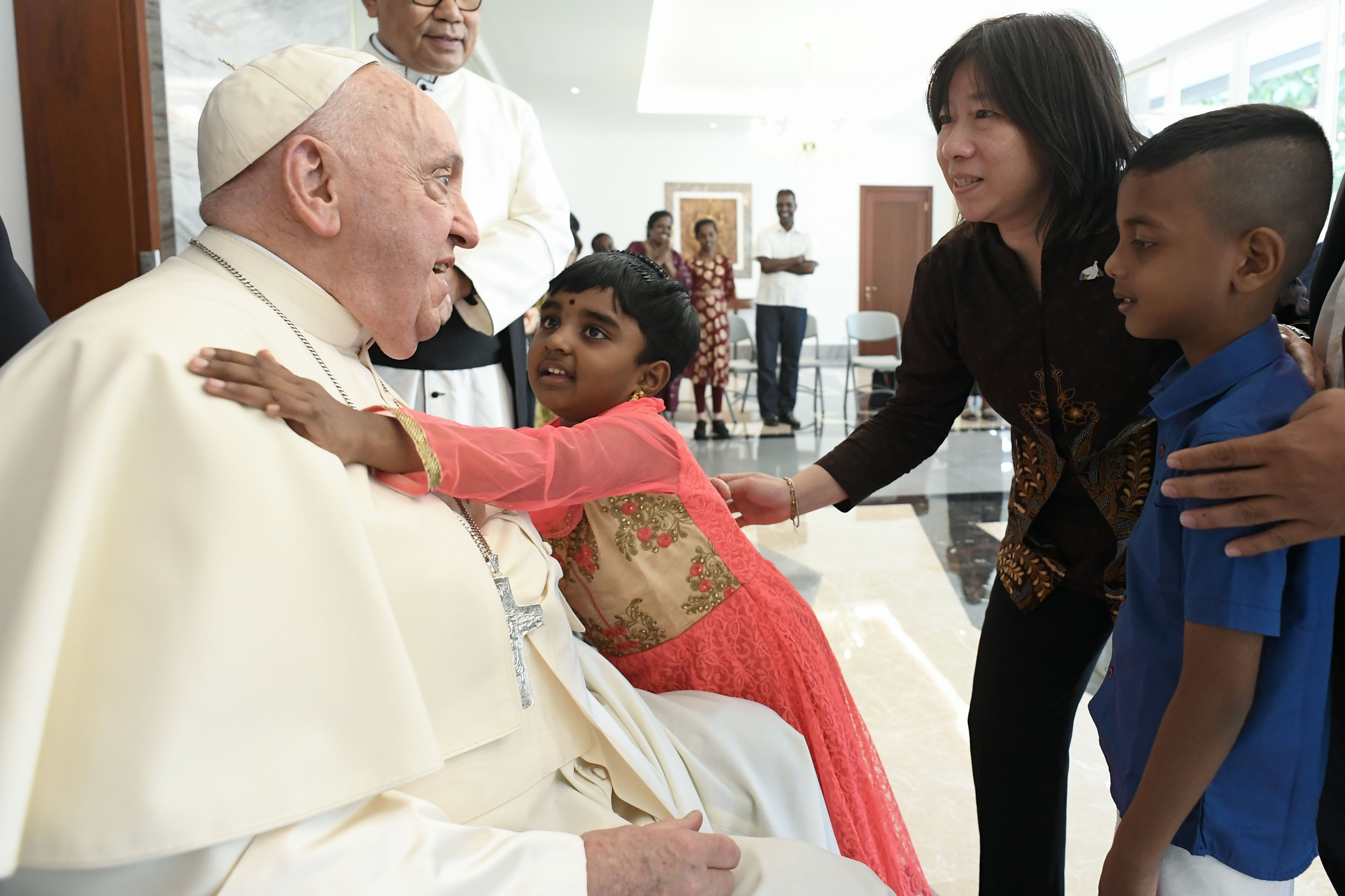 Pope Francis receives a hug from a child in Indonesia.