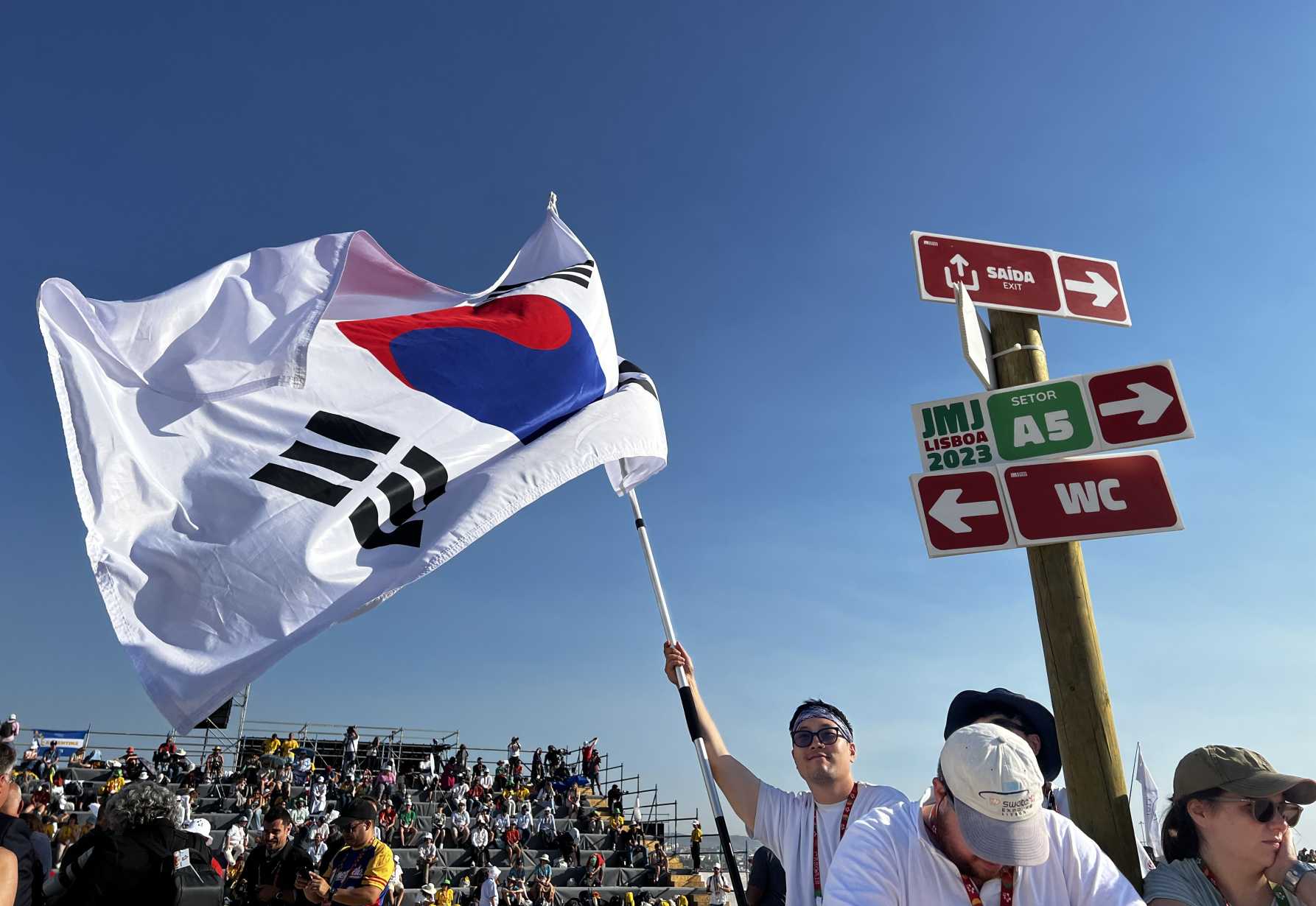 Pilgrims wave the flag of South Korea.