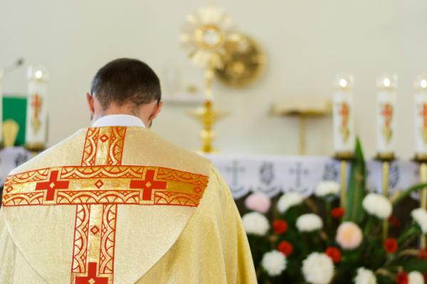 A priest praying before the blessed Sacrament (The Eucharist)