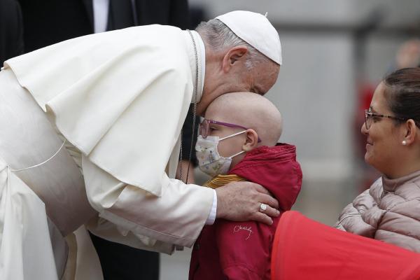 Pope Francis hugs a sick child