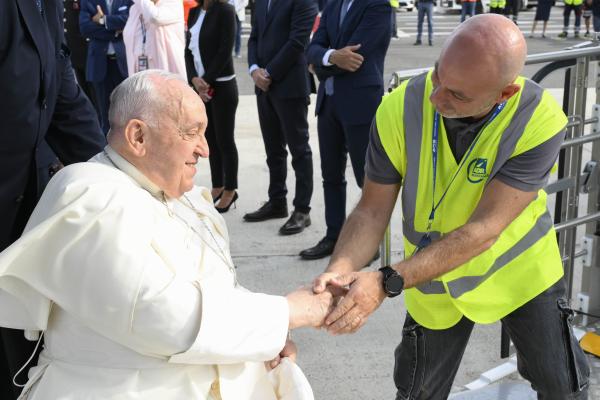 Pope Francis greets an airport worker.