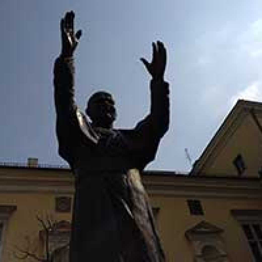 A statue of St. John Paul II with his arms raised in a greeting welcomes visitors to Krakow, Poland.