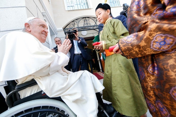 Pope Francis greets children in traditional Mongolian clothing. 