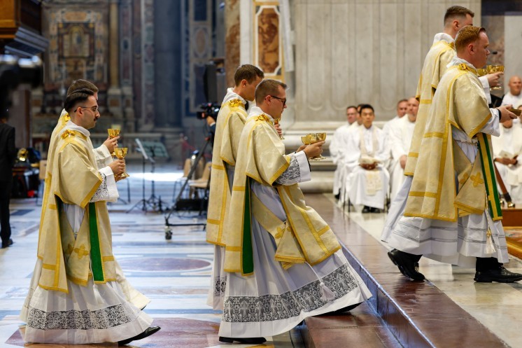 Newly ordained deacons carry offertory gifts.