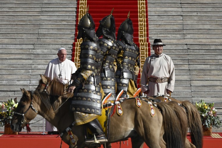 Members of a mounted honor guard, dressed in armor, ride past Pope Francis.