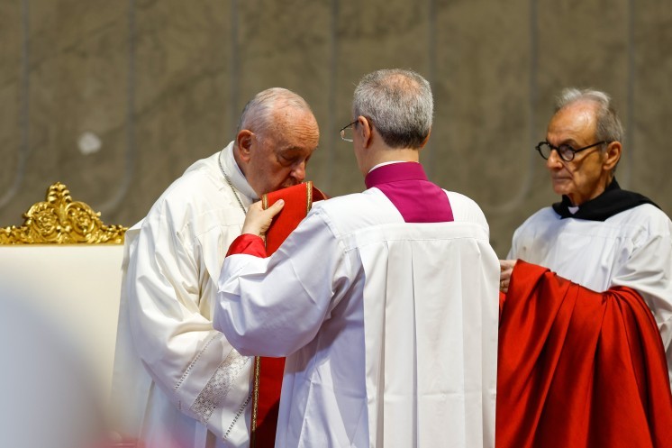 Pope Francis kisses his stole.