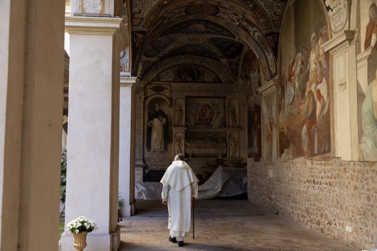 A Dominican friar walks in the cloister